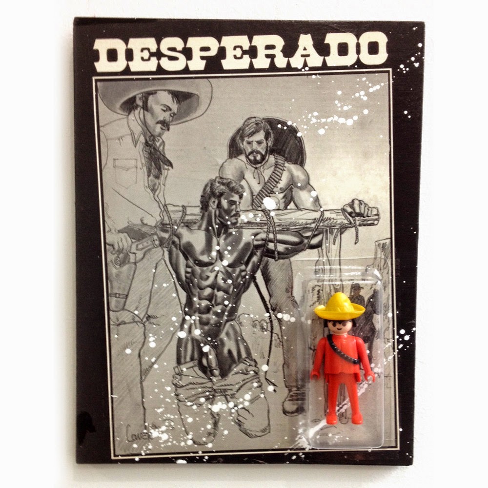 Small action figure wearing sombrero and ammo belt in packaging that says "Desperado" covered in an image of two men strapping the arms of another man with glistening muscles and exposed penis to a wooden log. 