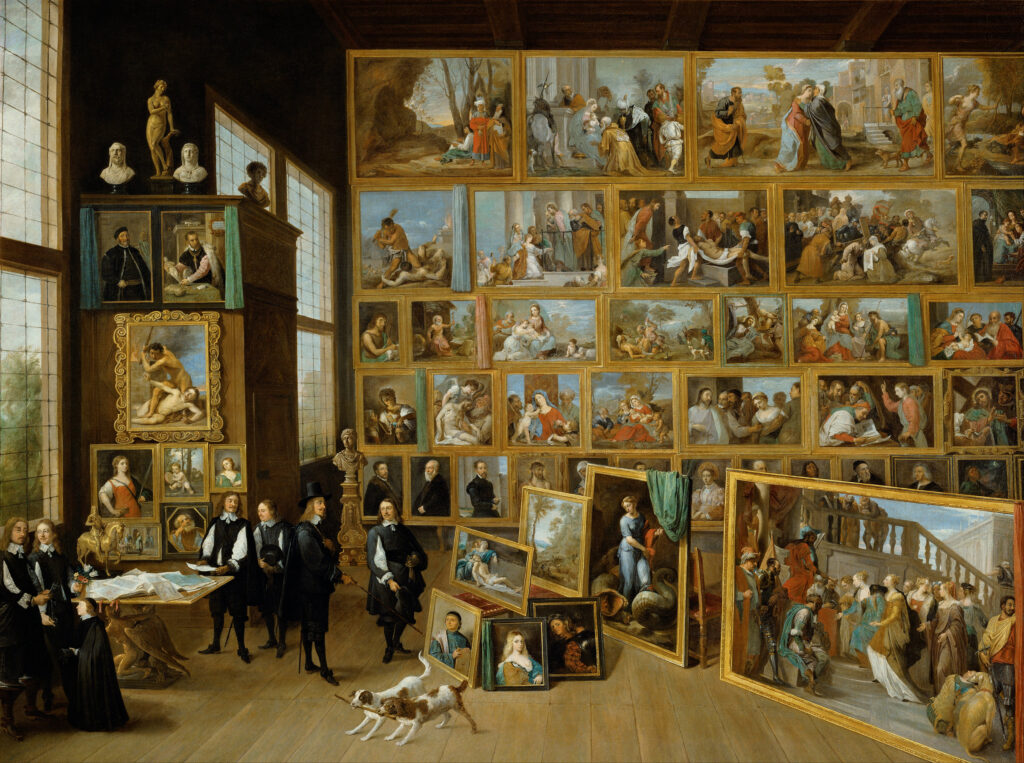 A painting made in a classical style in which several figures gather in the bottom left corner around a table. The remaining space is filled with smaller facsimile's of other paintings, made in a similar style. Some fill a wall of this expansive room, others stand on the floor.