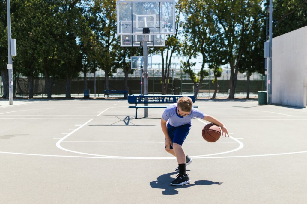 Action shot of a school-aged boy dribbling a basketball