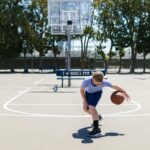 Action shot of a school-aged boy dribbling a basket ball.