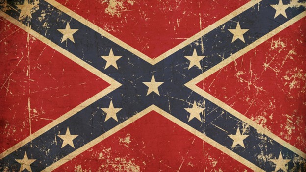 An image of a confederate flag (a blue X adorned with white stars on a red background) that appears worn.